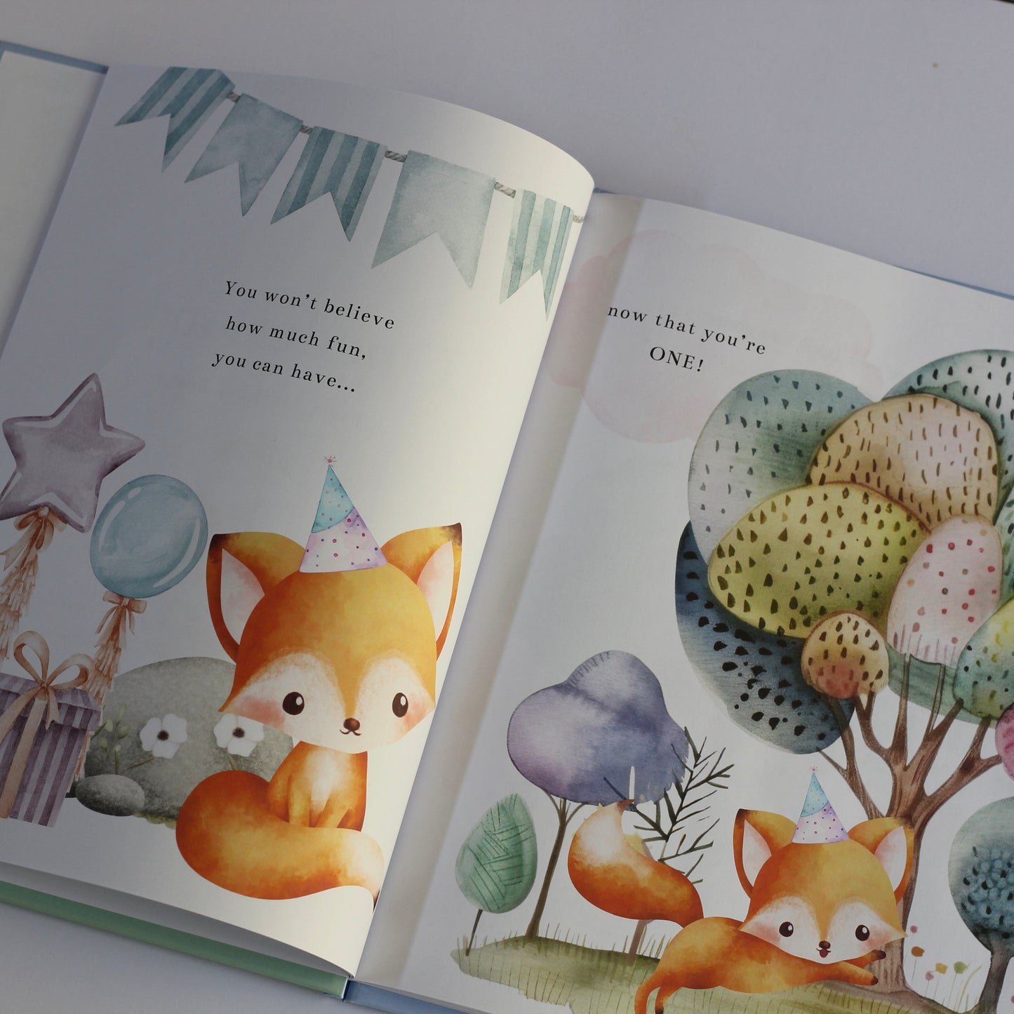 Open children's picture book Onederland with illustrations of foxes and colorful trees on a white background